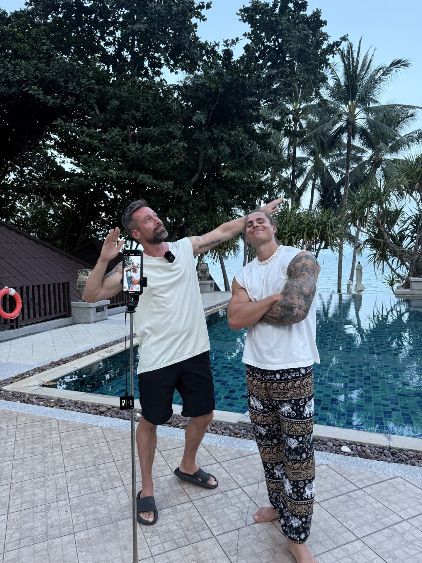 Timon and Marius filming content by a pool